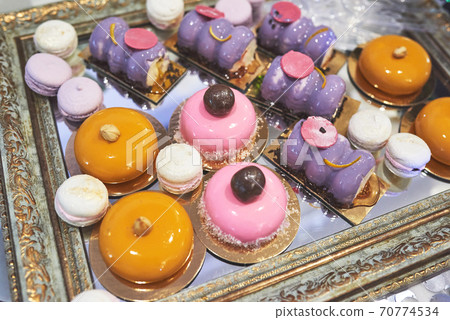 delicious colorful cookies and cakes on the wedding candy bar. 70774534