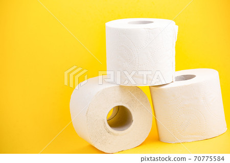 A large white toilet paper roll for use in bathrooms or kitchens, used for cleaning dirt in the bathroom on yellow background A large white toilet paper roll for use in bathrooms or kitchens, used for cleaning dirt in the bathroom on yellow background 70775584