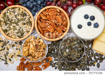 Group Nuts put on the bowl and fruit is banana,pineapple and grape is food healthy on the wooden table background Group Nuts put on the bowl and fruit is banana,pineapple and grape is food healthy on the wooden table background 70775596