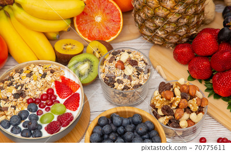 Group Fruits Breakfast mixed vegetables with salad bowl, nuts bowl, strawberry, banana, and pineapple, orange juice,  vitamin c in food  nature for health and diet in the top view on the wood table. 70775611