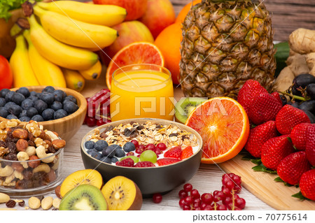 Group Fruits Breakfast mixed vegetables with salad bowl, nuts bowl, strawberry, banana, and pineapple, orange juice,  vitamin c in food  nature for health and diet in the top view on the wood table. 70775614