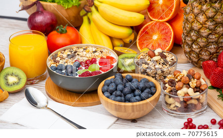 Group Fruits Breakfast mixed vegetables with salad bowl, nuts bowl, strawberry, banana, and pineapple, orange juice,  vitamin c in food  nature for health and diet in the top view on the wood table. 70775615