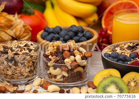 Group Fruits Breakfast mixed vegetables with salad bowl, nuts bowl, strawberry, banana, and pineapple, orange juice,  vitamin c in food  nature for health and diet in the top view on the wood table. 70775616