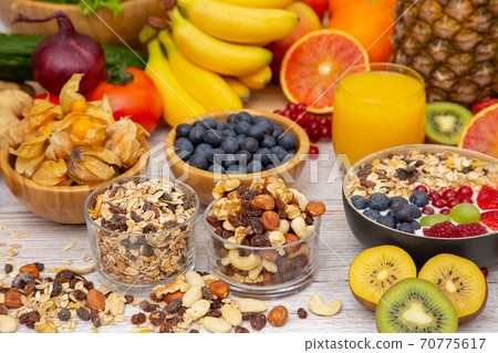 Group Fruits Breakfast mixed vegetables with salad bowl, nuts bowl, strawberry, banana, and pineapple, orange juice,  vitamin c in food  nature for health and diet in the top view on the wood table. 70775617