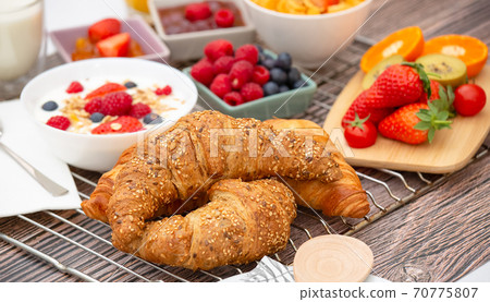 Breakfast Served in the morning with Fruit Yogurt, Butter croissant and corn flakes Whole grains and raisins with milk in cups and Strawberry, Raspberry, Kiwi, Fresh Orange Juice on breakfast table Breakfast Served in the morning with Fruit Yogurt, Butter croissant and corn flakes Whole grains and raisins with milk in cups and Strawberry, Raspberry, Kiwi, Fresh Orange Juice on breakfast table 70775807