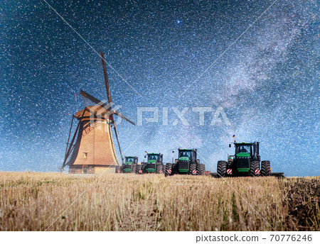 Colorful spring night with traditional Dutch windmills canal in Rotterdam. Wooden pier near the lake shore. Holland. Netherlands. Fantastic starry sky and the milky way. 70776246