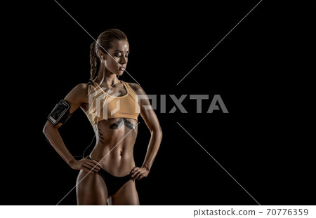 young fitness woman with earphones listens to young fitness woman with earphones listens to 70776359