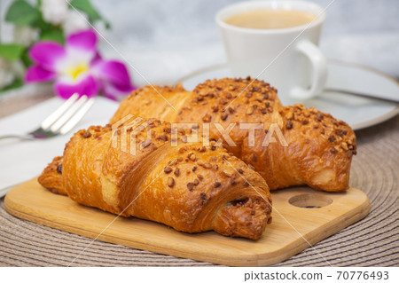 Fresh fragrant bread with and coffee beautiful flower is a good breakfast for the body on the table. 70776493