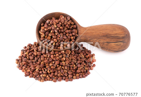 Guinea pepper grains in wooden spoon, isolated on white background. Melegeta, alligator pepper or mahlab. Grains of paradise. 70776577
