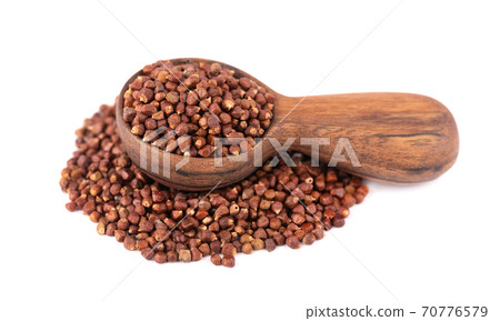 Guinea pepper grains in wooden spoon, isolated on white background. Melegeta, alligator pepper or mahlab. Grains of paradise. 70776579