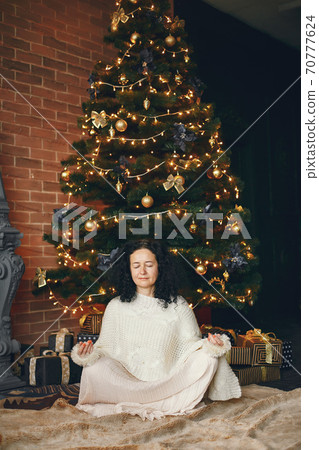 Elegant mature woman at home near christmas tree 70777624