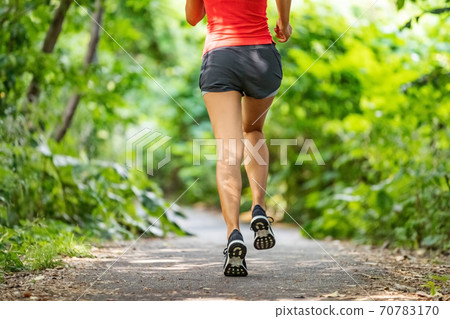 Runner running legs from the back jogging on nature path outside. Running shoes girl training cardio outdoors Runner running legs from the back jogging on nature path outside. Running shoes girl training cardio outdoors 70783170