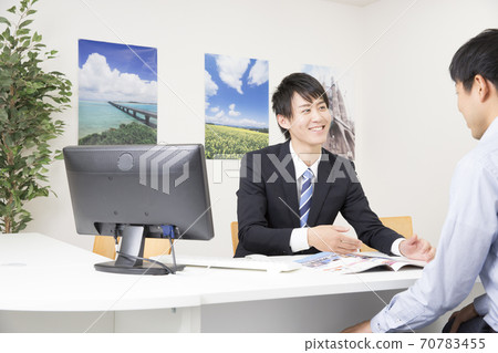 Male staff at a travel agency explaining Male staff at a travel agency explaining 70783455