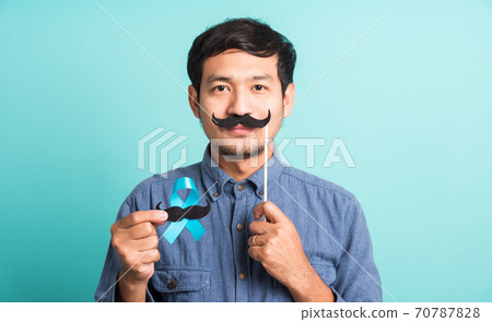 handsome man posing he holding a light blue ribbon and mustache handsome man posing he holding a light blue ribbon and mustache 70787828