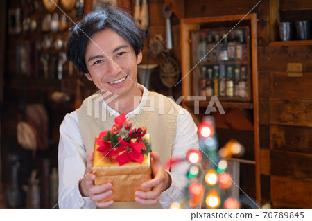 Christmas young man trying to give her a present Christmas young man trying to give her a present 70789845