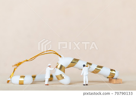 Miniature people,  Worker team painting a Christmas decoration 70790133