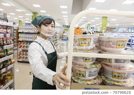 A female employee with a mouse shield carrying goods at a supermarket 70790628