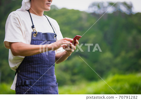 A man farming on a smartphone 70791282