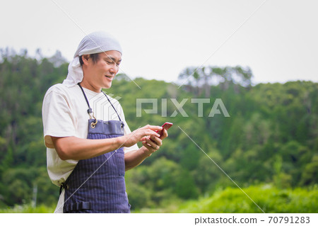 A man farming on a smartphone 70791283