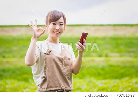 A woman farming on her smartphone 70791588