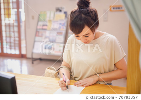 一個女人在接待處寫點東西 一個女人在接待處寫點東西 70793357