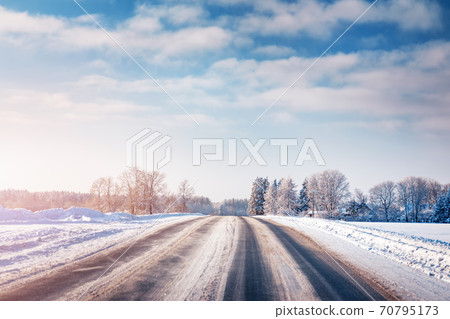 Winter road with snow and trees all around Winter road with snow and trees all around 70795173
