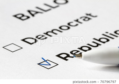 Checklist concept. Closeup of ballot paper with words Democrat and Republican and a pen on it. A checkmark for Republican in the checkbox. Checklist concept. Closeup of ballot paper with words Democrat and Republican and a pen on it. A checkmark for Republican in the checkbox. 70796797