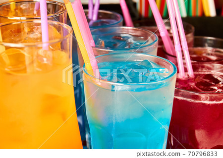 Multicolored alcoholic and non-alcoholic cocktails with ice and straws Multicolored alcoholic and non-alcoholic cocktails with ice and straws 70796833