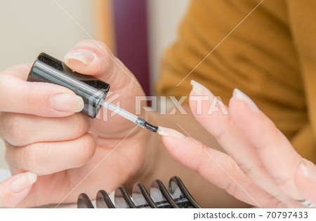 Woman painting manicure / Image of nail salon Woman painting manicure / Image of nail salon 70797433
