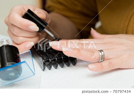 Woman painting manicure / Image of nail salon Woman painting manicure / Image of nail salon 70797434
