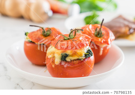 baked tomatoes stuffed with cheese and spinach 70798135
