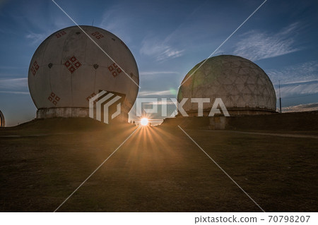 Dramatic sunrise over uniquely designed old radar station in shape of white spheres with red pattern Dramatic sunrise over uniquely designed old radar station in shape of white spheres with red pattern 70798207