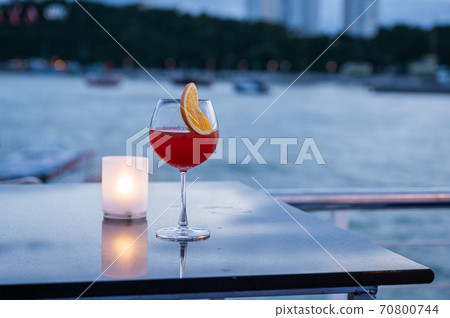 Orange juice cocktail in wine glass and lamp on table Orange juice cocktail in wine glass and lamp on table 70800744