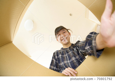 A girl who opens a product bought by mail order (view from the inside) A girl who opens a product bought by mail order (view from the inside) 70801792