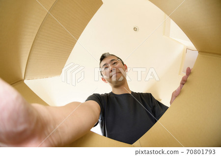 A man who opens a product bought by mail order (view from the inside) A man who opens a product bought by mail order (view from the inside) 70801793