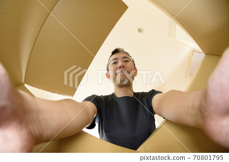 A man who opens a product bought by mail order (view from the inside) A man who opens a product bought by mail order (view from the inside) 70801795