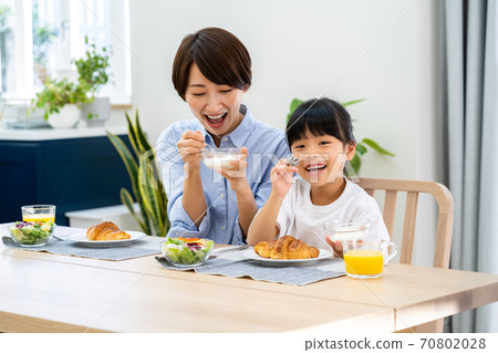 父母和孩子在飯廳裡吃早餐。 父母和孩子在飯廳裡吃早餐。 70802028