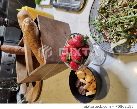 Fresh strawberries in a glass bowl on a light-colored table. Light diet Breakfast Fresh strawberries in a glass bowl on a light-colored table. Light diet Breakfast 70802195
