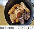 Round crackers made of white and rye bread on a dark-colored plate 70802197