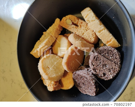 Round crackers made of white and rye bread on a dark-colored plate Round crackers made of white and rye bread on a dark-colored plate 70802197