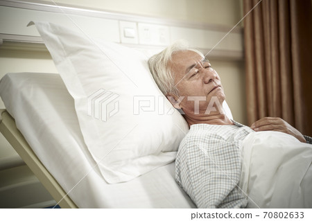asian elderly male patient lying in bed sleeping in hospital ward or assisted living facility asian elderly male patient lying in bed sleeping in hospital ward or assisted living facility 70802633