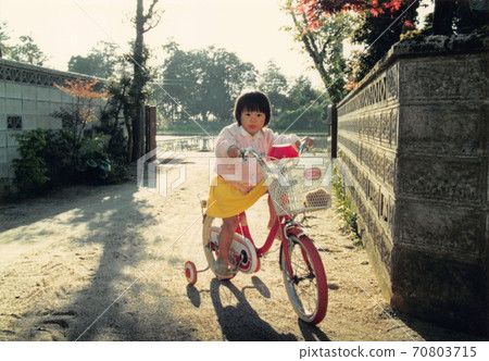 老電影照片:一個女孩第一次騎著帶有輔助輪的自行車 老電影照片:一個女孩第一次騎著帶有輔助輪的自行車 70803715