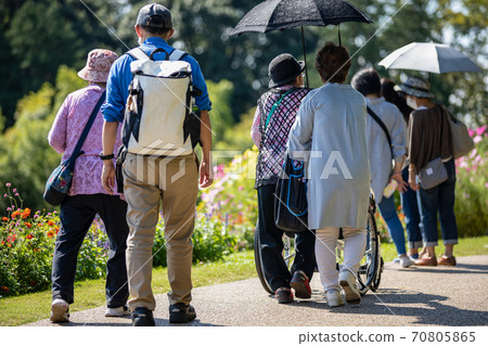 在公園散步的年長者和照顧者 在公園散步的年長者和照顧者 70805865