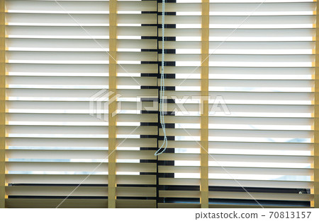 Wooden blinds with daylight illuminating through 70813157