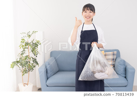 年輕女子手裡拿著一個垃圾袋 70813439