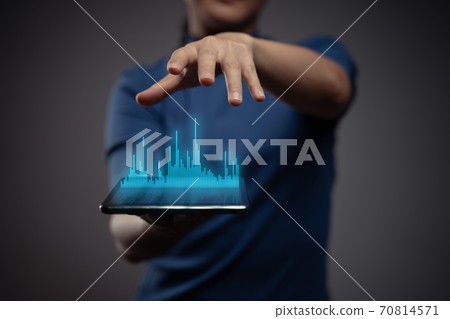 Woman using tablet with chart hologram effect. 70814571