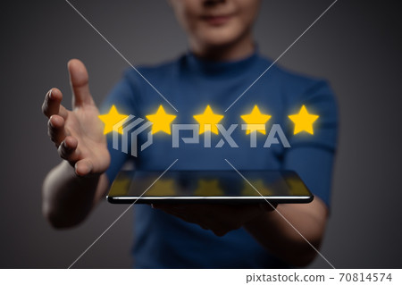 Woman showing tablet present five stars icon hologram effect. Woman showing tablet present five stars icon hologram effect. 70814574