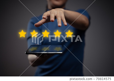 Woman showing tablet present five stars icon hologram effect. Woman showing tablet present five stars icon hologram effect. 70814575