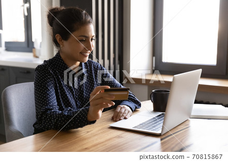 Smiling Indian woman shopping online with credit card Smiling Indian woman shopping online with credit card 70815867