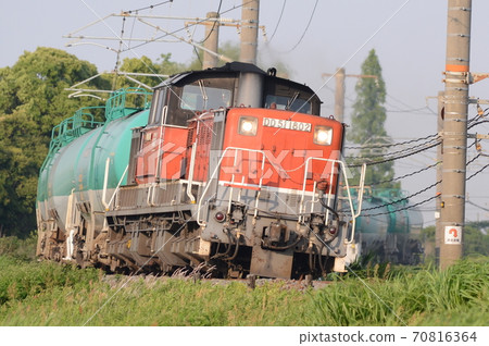 A freight train that returns an empty tank car to an oil base while bathing in the setting sun 70816364